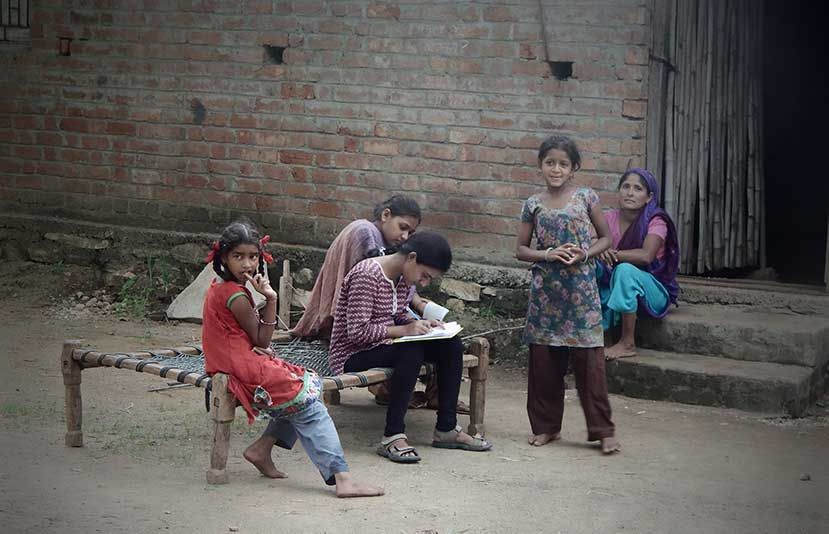 गुजरात, भारत - जून, 2015: एक आदिवासी गांव में लड़की सर्वे करती हुई (श्रोत: शटरस्टॉक)