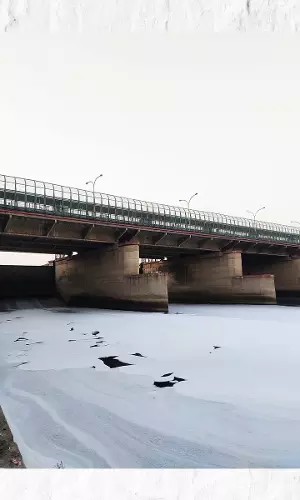 यमुना पर दूर तक फैली सफ़ेद झाग की कालीन