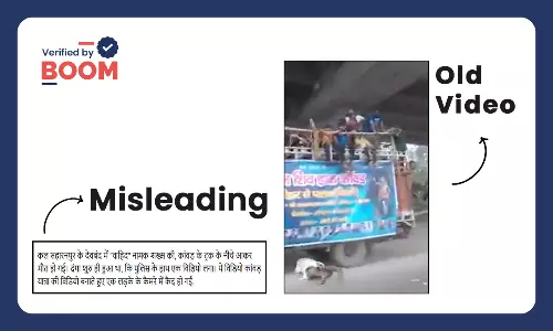 a man jumping under a truck carrying Kanwariyas in UP